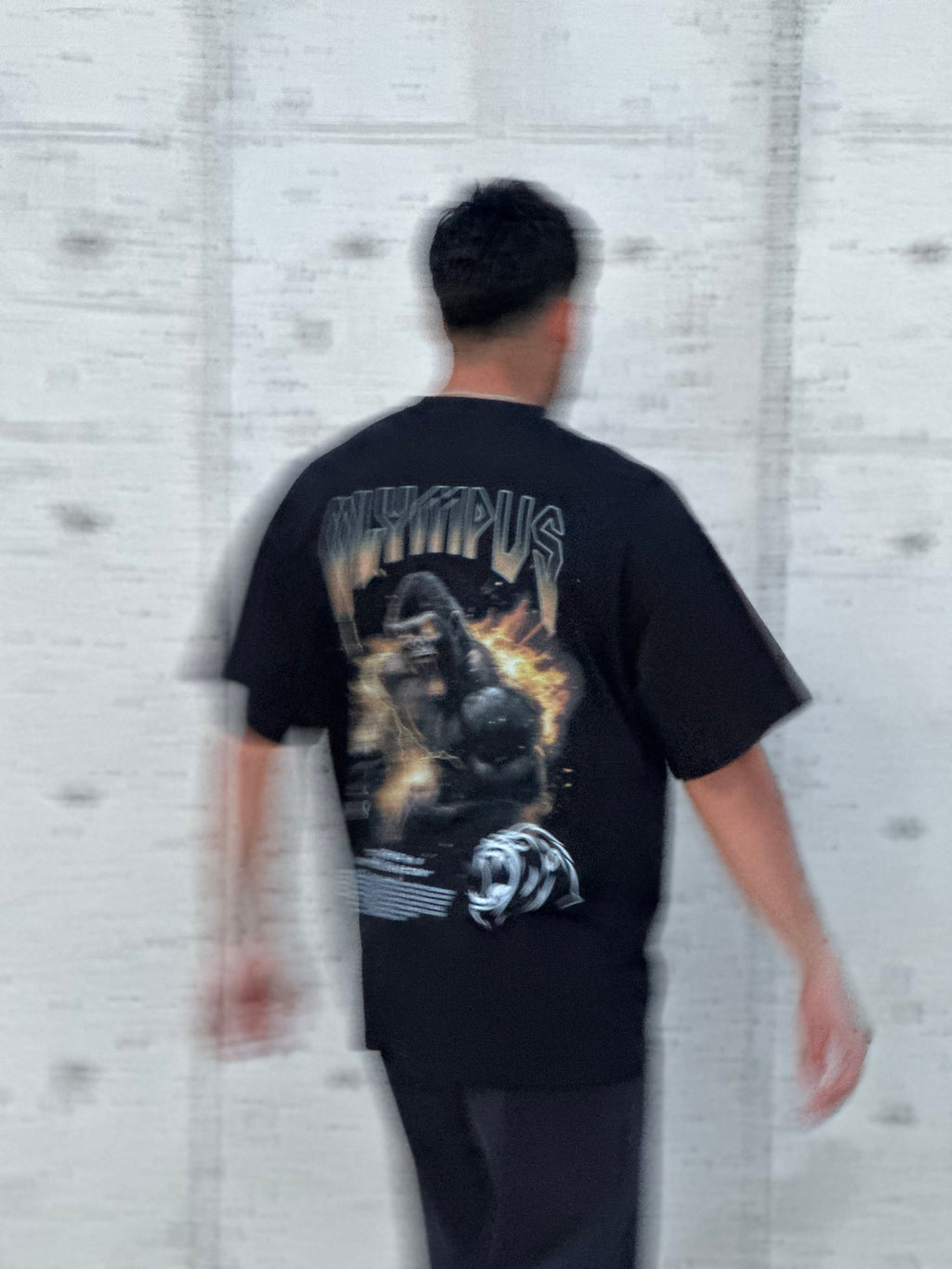  OLYMPUS Gorilla heavyweight graphic tee in black back design on model outside blurry